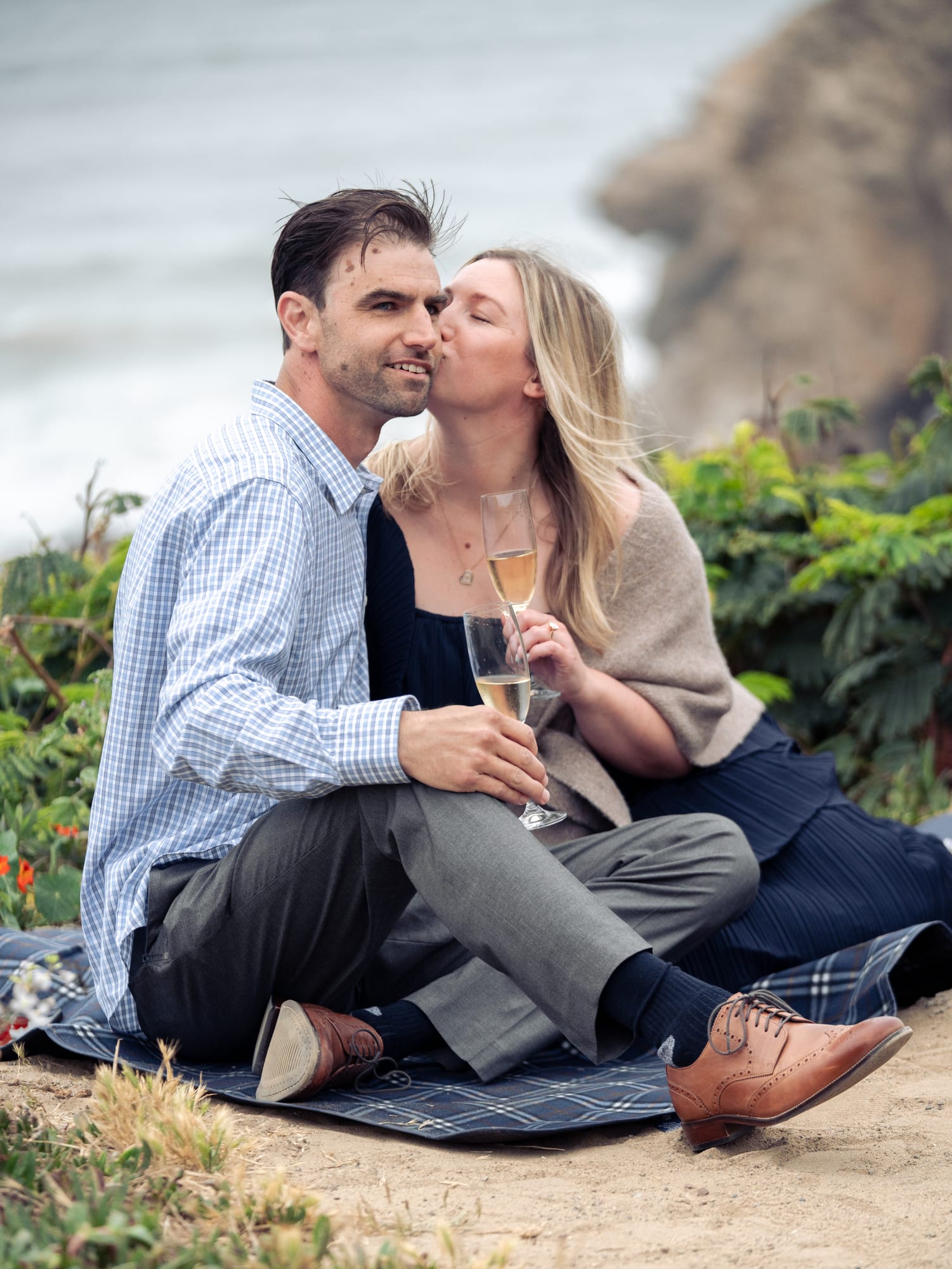 The couple cheek to cheek, her eyes closed and laughing, her ring hand resting on his chest